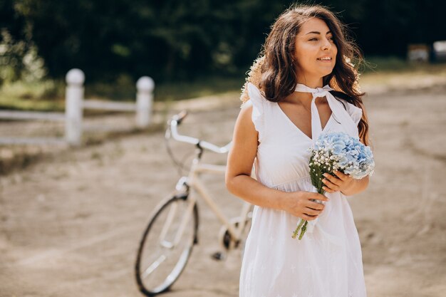 ビーチで自転車に乗って花を持つ女性