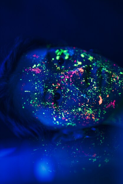 Woman with fluorescent make-up on face