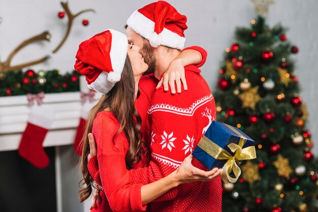 Женщина с подарком обниматься и целовать человека