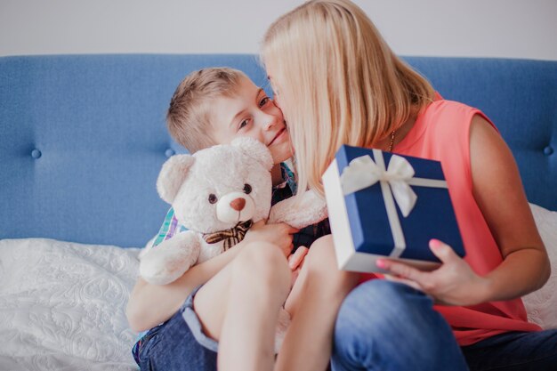 Woman with gift kissing her son