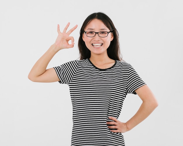 Woman with glasses giving the ok sign