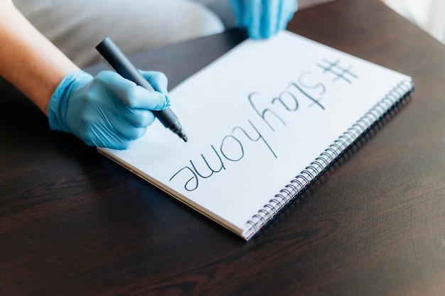 Woman with gloves writing on notebook