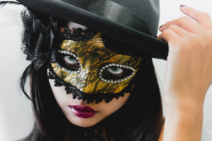 無料Photo 黄金のベネチアンマスクと白い背景に黒い帽子を持つ女性