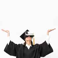 Free photo woman with graduation robe and cap wearing virtual reality headset