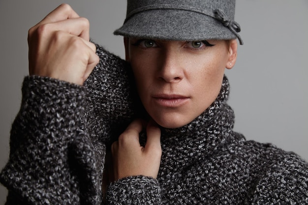 녹색 눈을 가진 여자는 회색 스웨터와 모자 가을 이미지 개념을 착용