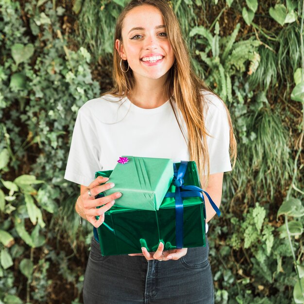 Woman with green gift boxes looking at camera