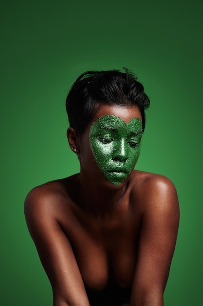 Woman with a green shiny heart on a face