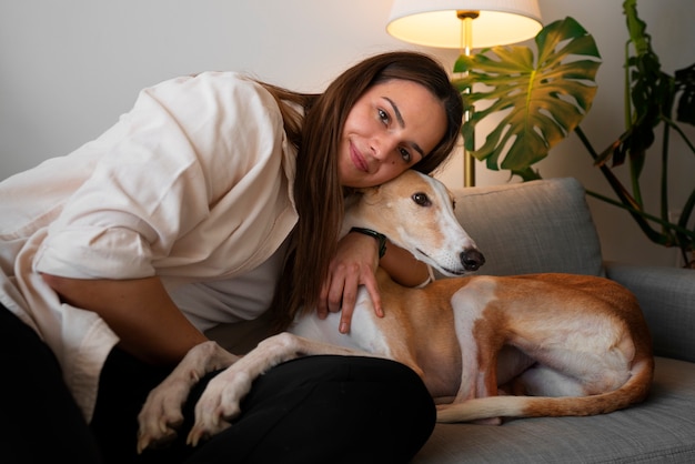 Foto gratuita donna con cane levriero a casa sul divano