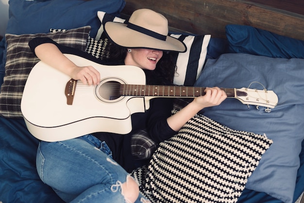 Бесплатное фото Женщина с гитарой и шляпой