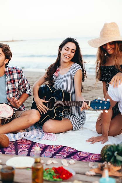 Woman with guitar at a beach party