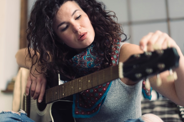 Woman with guitar at home