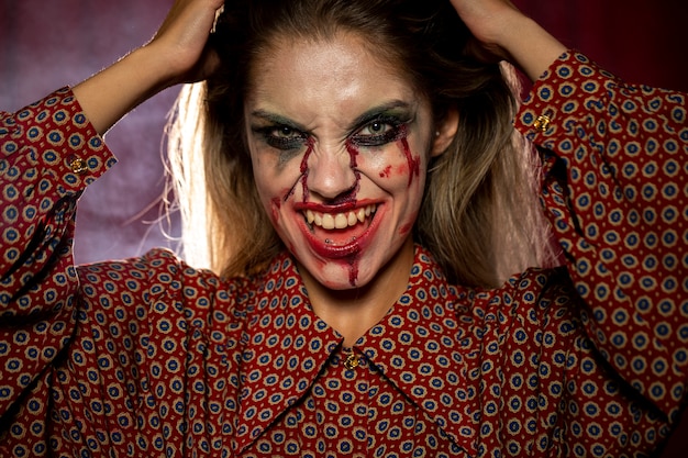 Foto gratuita donna con il sorriso di trucco del burlone di halloween