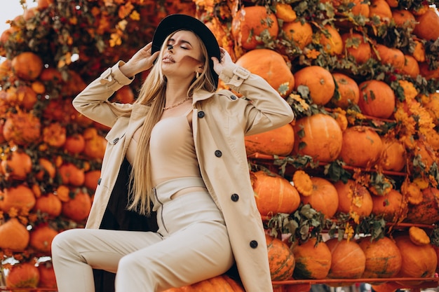 Woman with halloween make up standing by halloween pumpkins