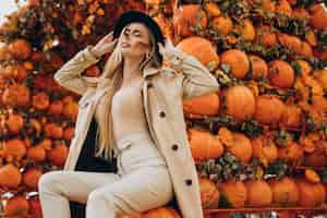 Free photo woman with halloween make up standing by halloween pumpkins