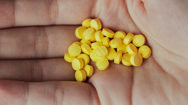 Woman with a handful of yellow pills