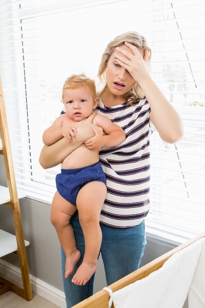 Woman with headache and a baby in arms