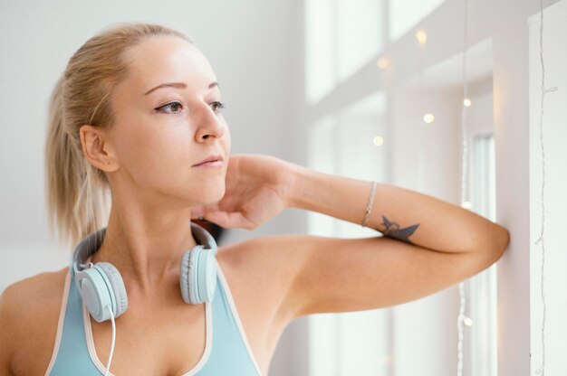 Woman with headphones looking out on window