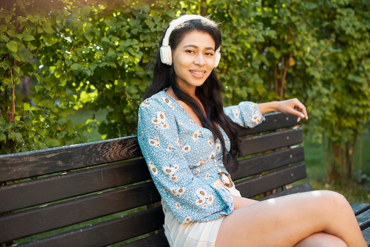 無料Photo 座っていると私たちを見てヘッドフォンを持つ女性