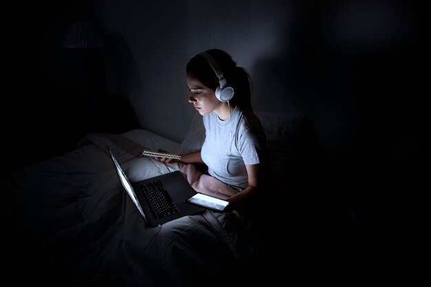 Woman with headphones working late at home