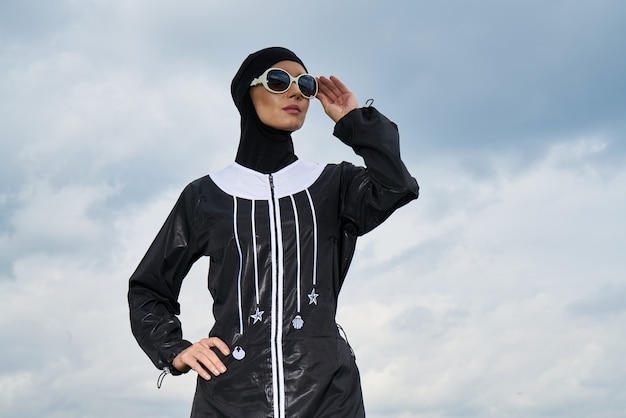 Free photo woman with headscarf and sunglasses with clouds background