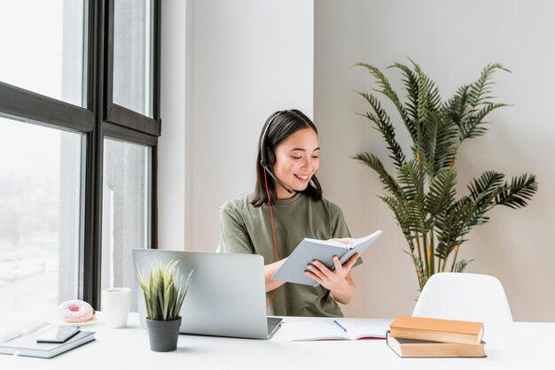 Woman with headset having video call on laptop