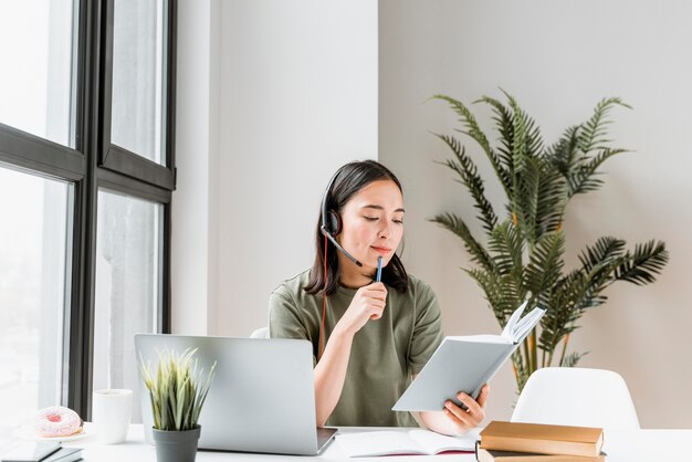 Woman with headset having video call on laptop