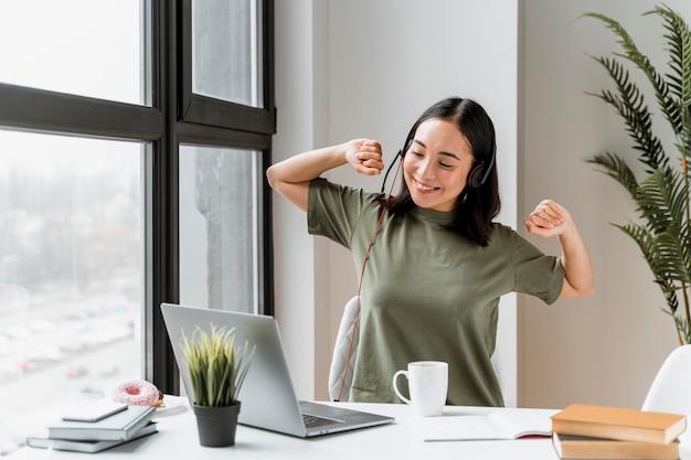 Woman with headset having video call on laptop