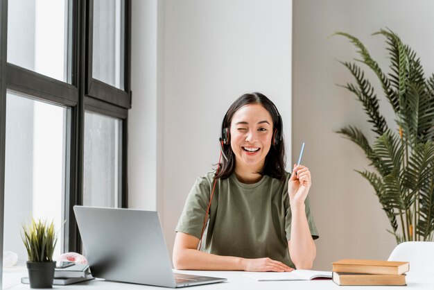 Woman with headset having video call on laptop