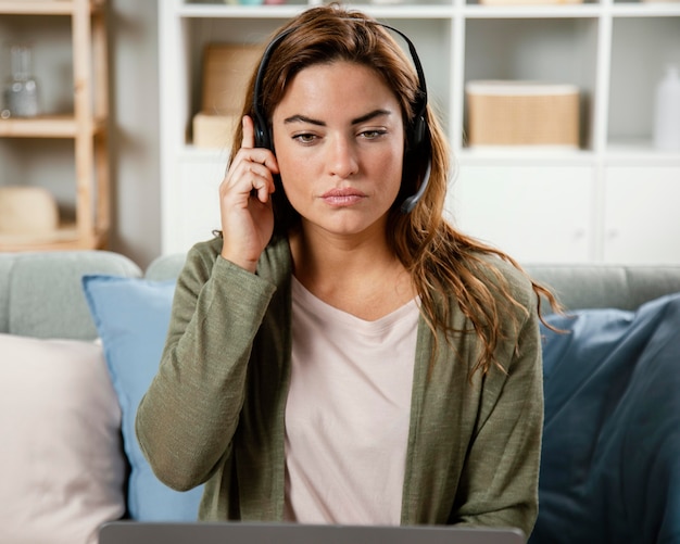 Woman with headset having video call on laptop