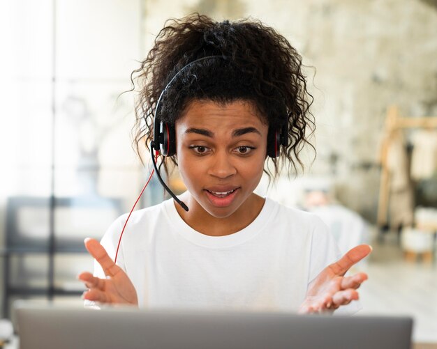 Woman with headset and laptop working from home