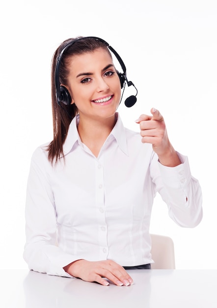 Woman with headset pointing at you