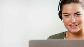Free photo woman with headset using laptop