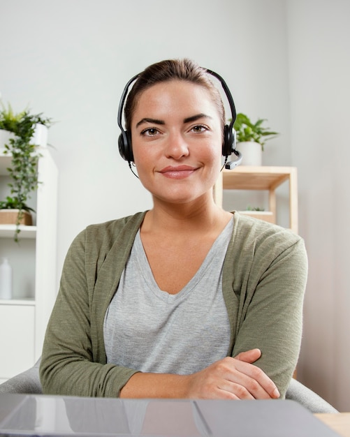 Foto gratuita donna con auricolare utilizzando laptop