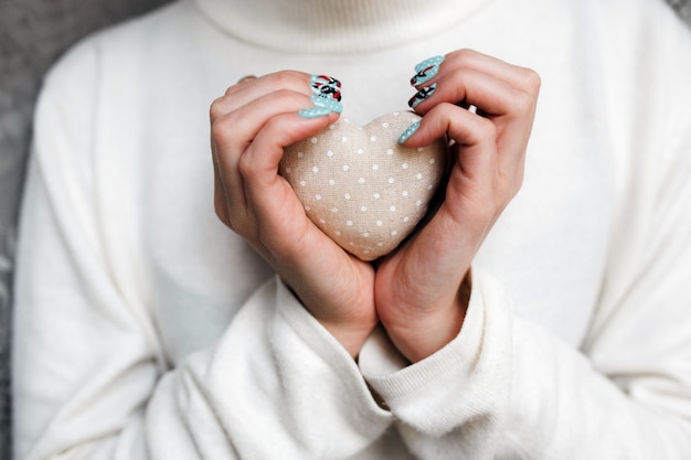 La donna con una pietra a forma di cuore in mano