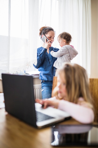 Woman with her baby girl talking on cellphone