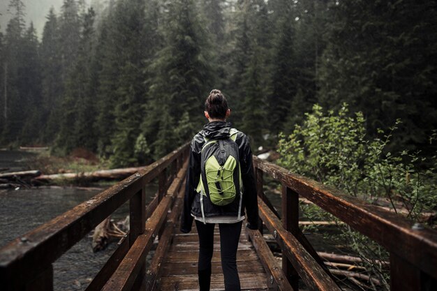 Woman with her backpack standing on wooden bridge