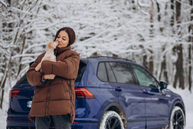 車のそばでかわいい犬を連れた女性