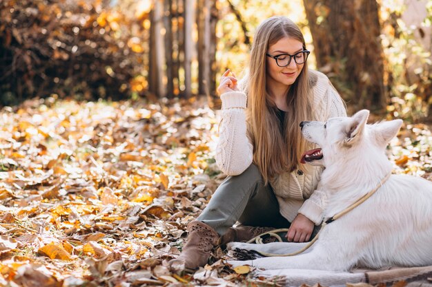 毛布に座っている公園で彼女の犬と女