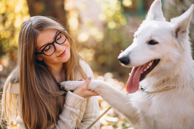 Woman with her dog in park sitting on blanket