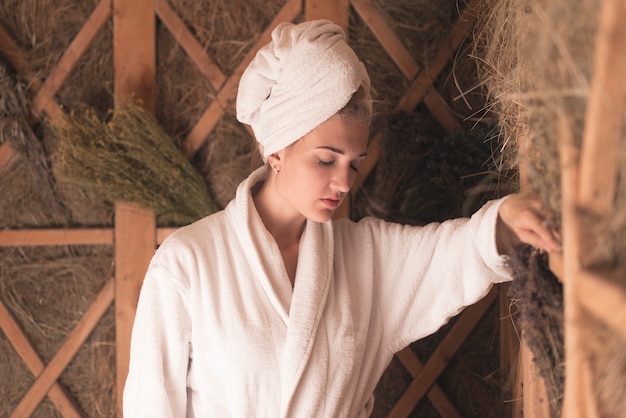 Free photo woman with her head wrapped in towel relaxing at sauna