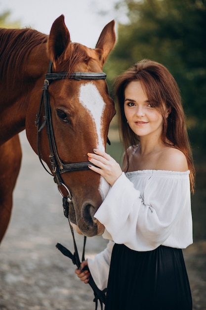 森の中で馬を持つ女性