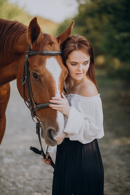 森の中で馬を持つ女性