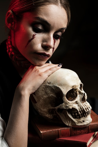 Woman with human skull and books