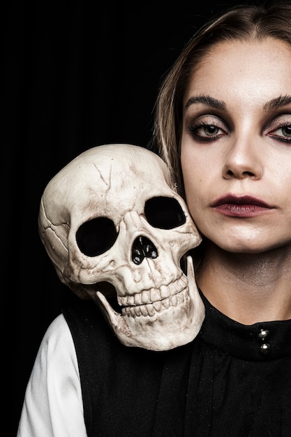 Free photo woman with human skull on shoulder