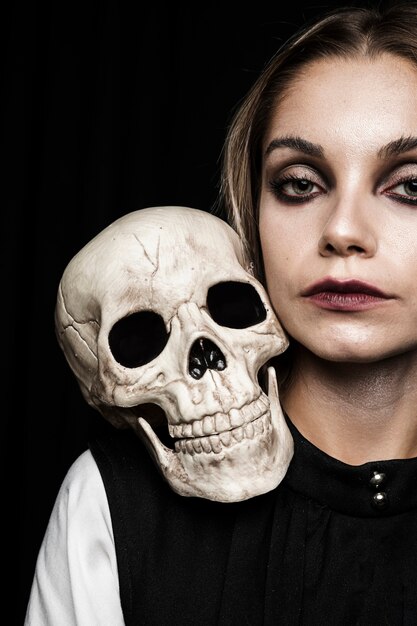 Woman with human skull on shoulder