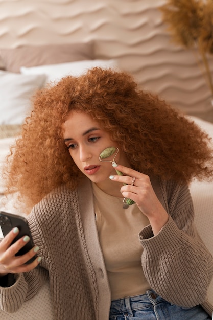 Woman with jade roller doing her beauty routine