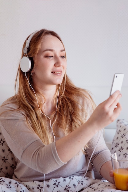 Woman with juice listening to music