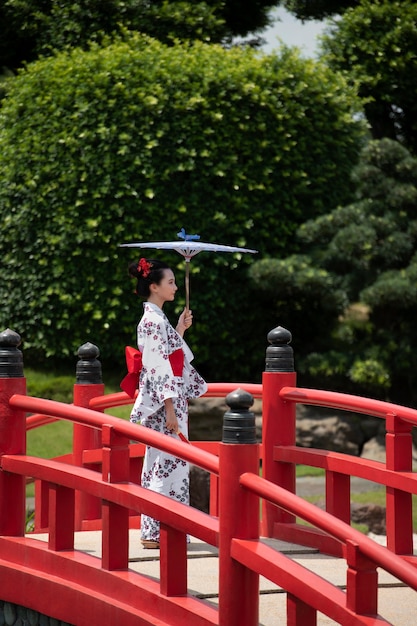 Бесплатное фото Женщина с кимоно и зонтиком вагаса