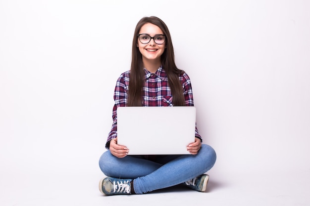 Foto gratuita donna con computer portatile seduto sul pavimento. isolato su bianco.