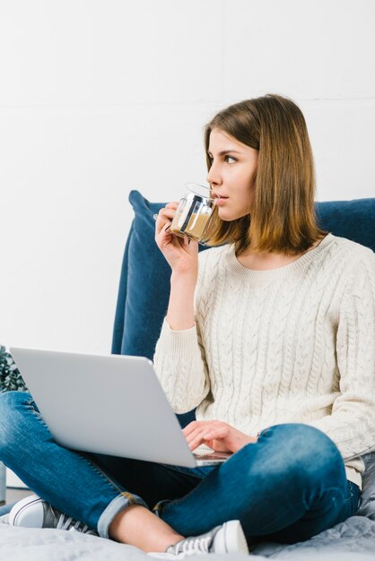 Woman with laptop drinking coffee